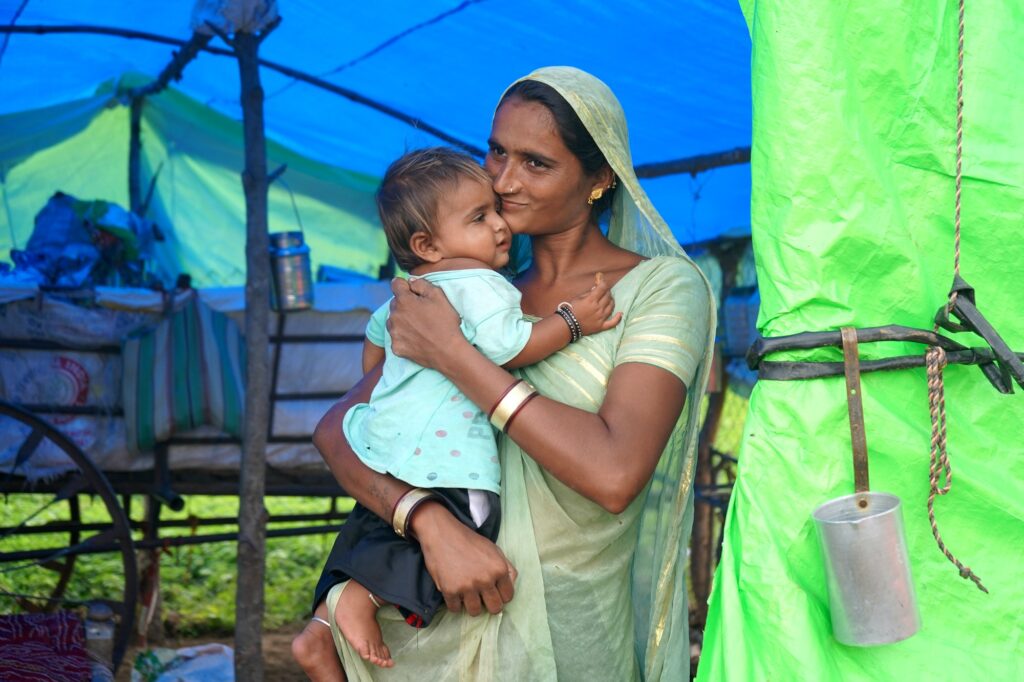 Nomadic tribe woman with baby at the tent, India.